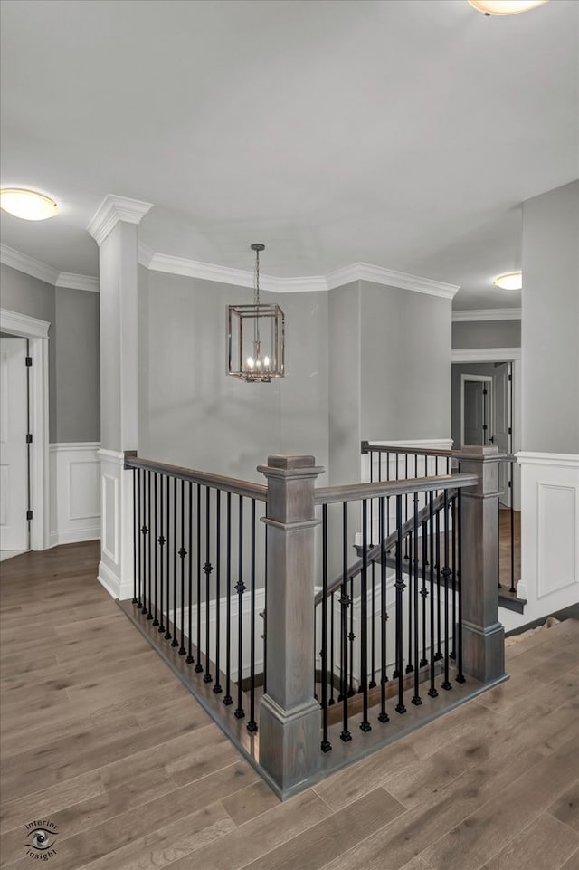 hallway featuring ornamental molding, a notable chandelier, and hardwood / wood-style floors