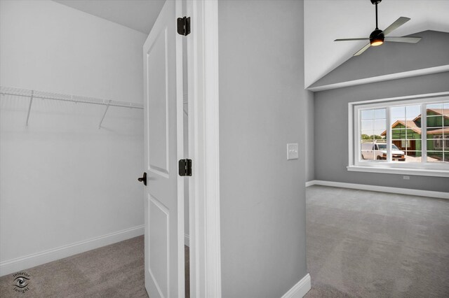 interior space featuring light carpet, ceiling fan, and vaulted ceiling