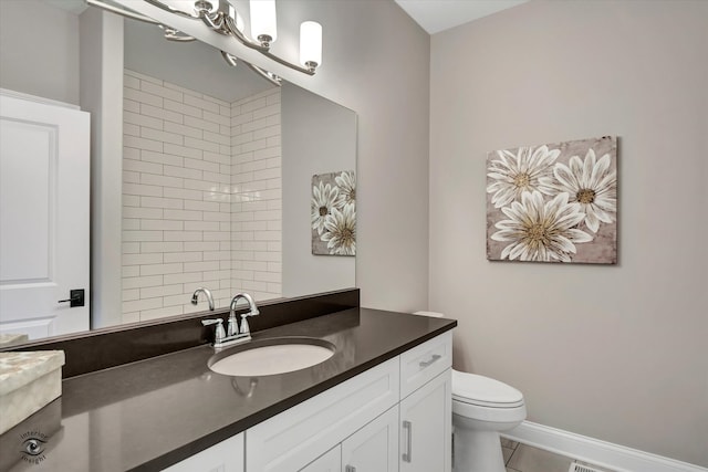 bathroom with vanity, toilet, and tile flooring