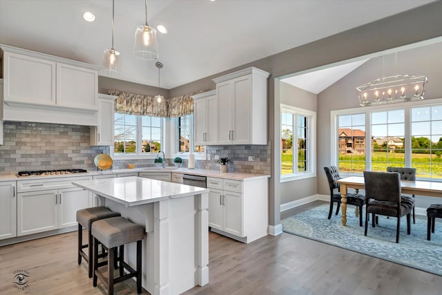 kitchen featuring light hardwood / wood-style flooring, a center island, white cabinetry, and tasteful backsplash