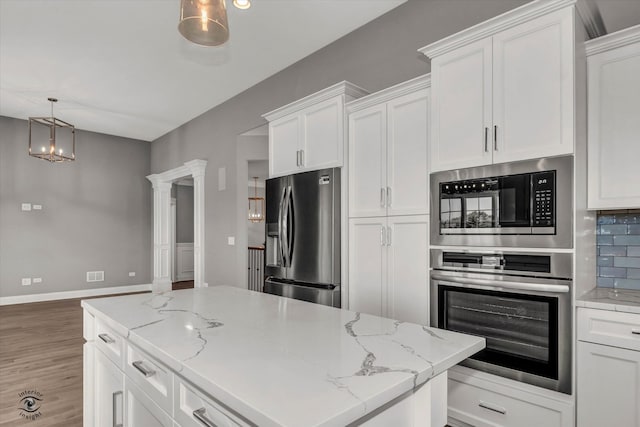 kitchen with pendant lighting, stainless steel appliances, and white cabinetry