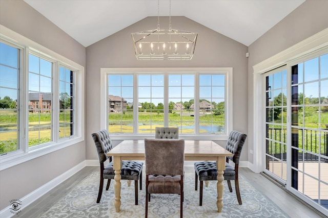 sunroom featuring a healthy amount of sunlight, lofted ceiling, and an inviting chandelier