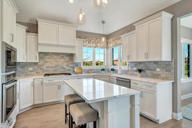 kitchen with sink, light hardwood / wood-style floors, tasteful backsplash, and stainless steel appliances