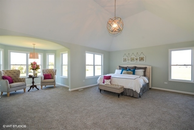 bedroom featuring vaulted ceiling, carpet, and an inviting chandelier