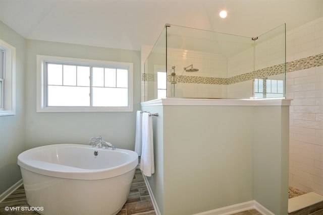 bathroom featuring tile flooring and separate shower and tub