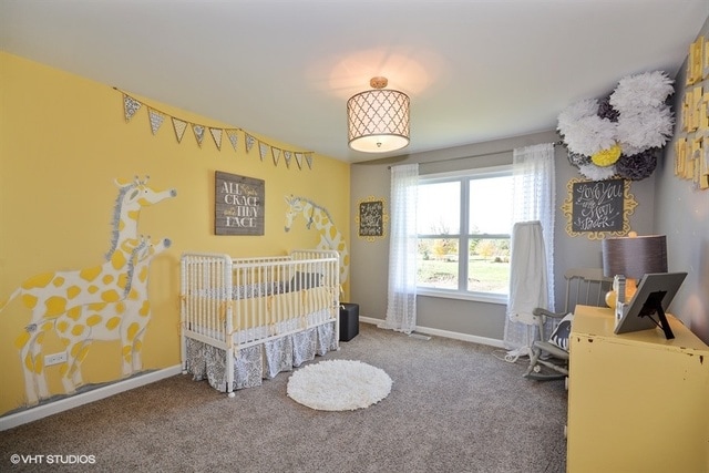 carpeted bedroom with a nursery area