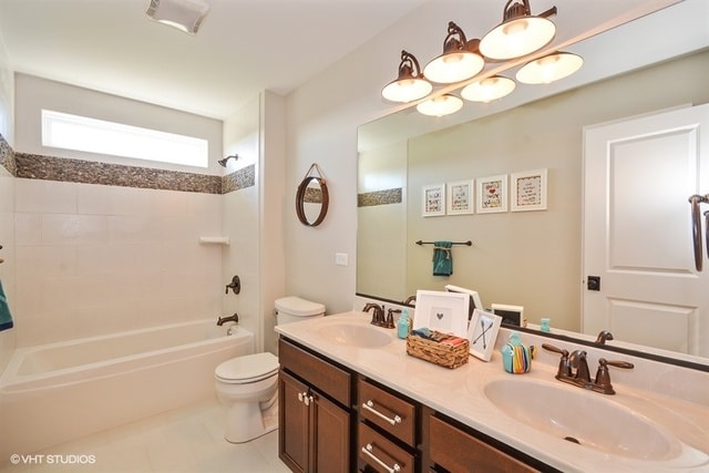 full bathroom featuring tile flooring,  shower combination, toilet, and double sink vanity