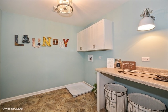 laundry area with hookup for a washing machine, tile flooring, and cabinets