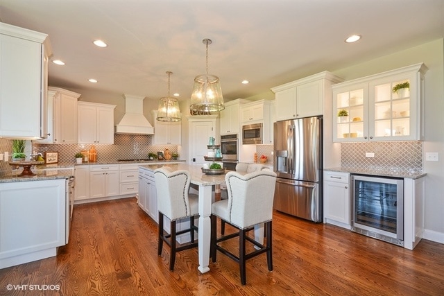 kitchen with wine cooler, custom exhaust hood, stainless steel appliances, and dark hardwood / wood-style floors