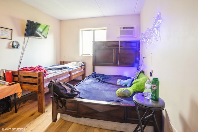 bedroom featuring a wall mounted air conditioner and hardwood / wood-style floors