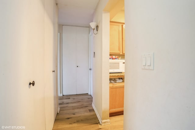 hallway with light hardwood / wood-style floors