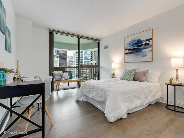 bedroom featuring dark hardwood / wood-style floors and a wall of windows