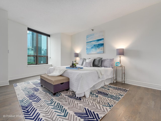 bedroom with dark hardwood / wood-style floors and a textured ceiling