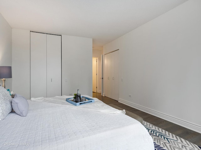 bedroom featuring two closets and dark wood-type flooring