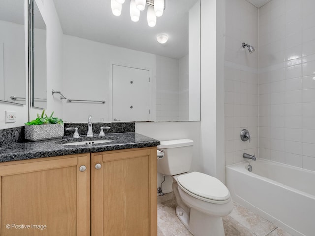 full bathroom featuring tiled shower / bath, toilet, tile floors, and vanity