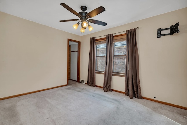 carpeted spare room featuring ceiling fan