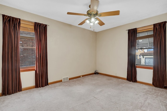 carpeted spare room featuring ceiling fan