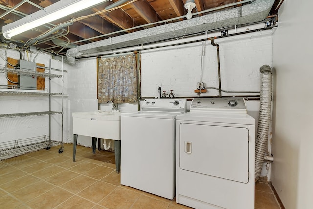 clothes washing area with washer and dryer and light tile flooring