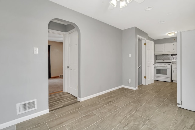 tiled empty room featuring ceiling fan