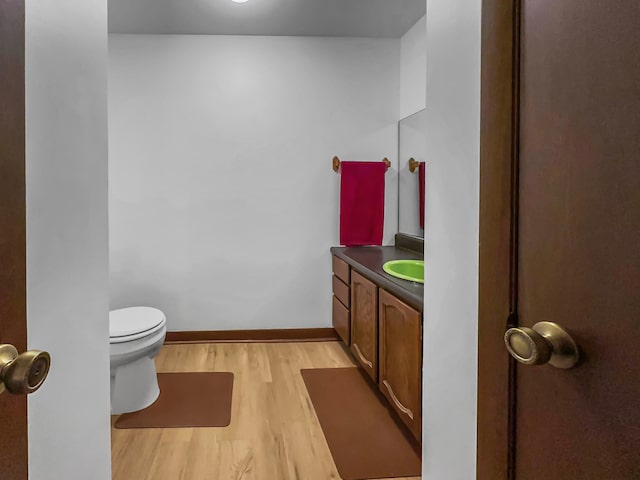 bathroom featuring vanity, hardwood / wood-style flooring, and toilet