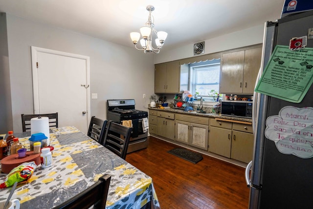 kitchen with gas range, built in microwave, dark hardwood / wood-style flooring, a notable chandelier, and stainless steel fridge