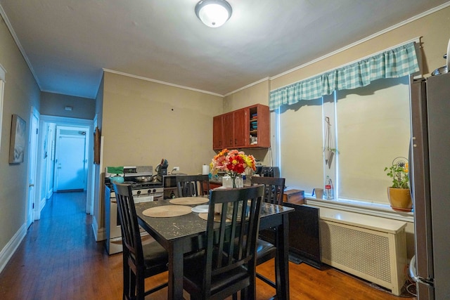 dining room with ornamental molding, radiator heating unit, and dark wood-type flooring