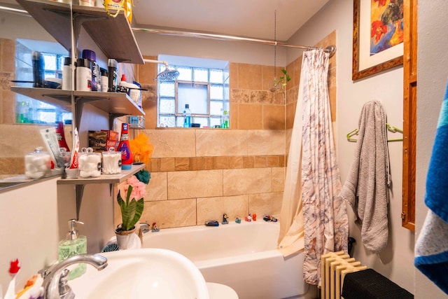 bathroom with shower / tub combo with curtain, sink, and radiator