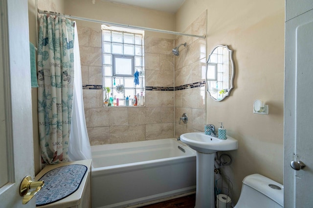 full bathroom featuring a healthy amount of sunlight, sink, toilet, and shower / bath combo with shower curtain