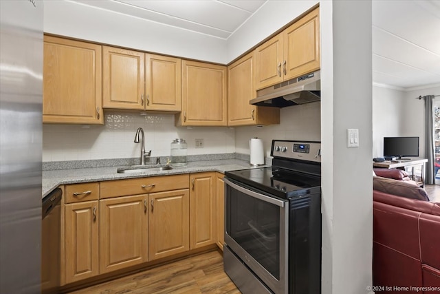 kitchen with appliances with stainless steel finishes, sink, light wood-type flooring, ornamental molding, and light stone countertops