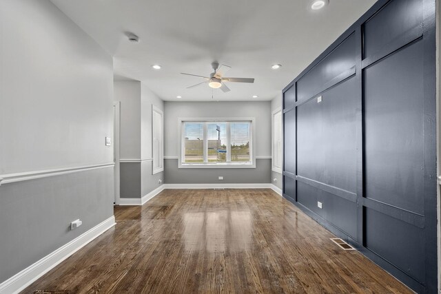 empty room with hardwood / wood-style floors and ceiling fan