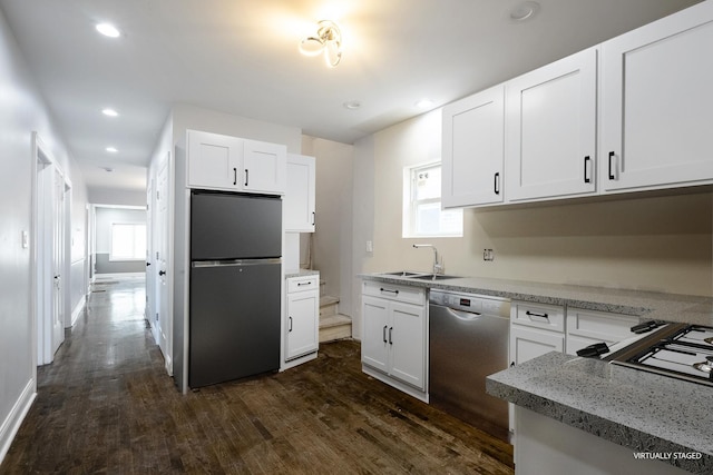 kitchen featuring dark wood-style floors, stainless steel appliances, white cabinetry, a sink, and recessed lighting