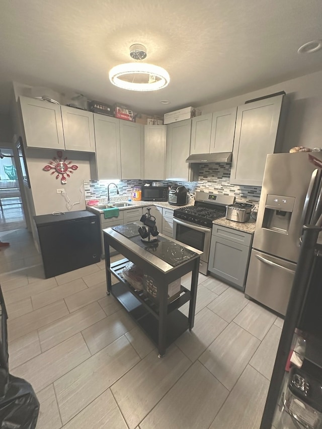 kitchen featuring backsplash, appliances with stainless steel finishes, sink, and gray cabinetry