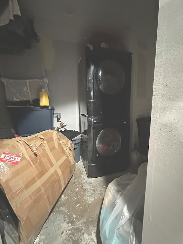 room details with stacked washer / dryer and concrete floors