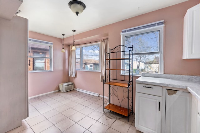 kitchen with white cabinets, decorative light fixtures, and light tile floors