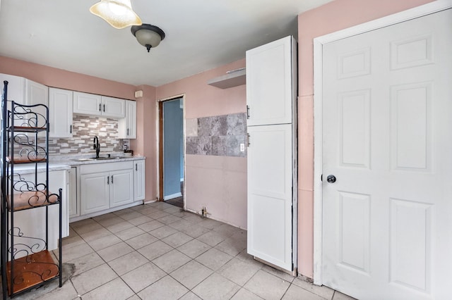 kitchen with light tile floors, white cabinets, and sink