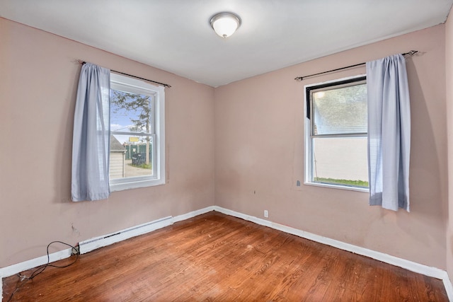 spare room featuring hardwood / wood-style flooring and baseboard heating