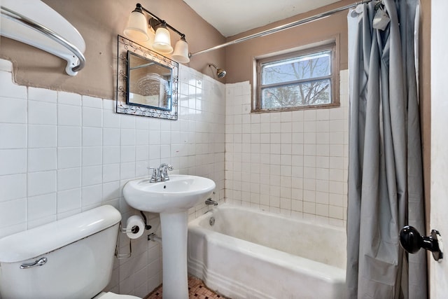 bathroom with shower / bath combo, toilet, and tile walls