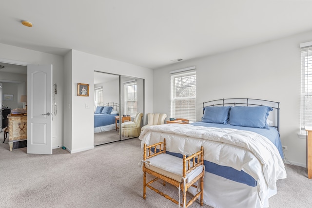 bedroom featuring light carpet and a closet