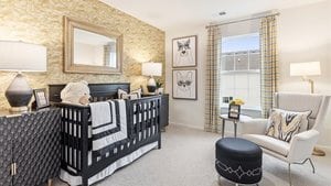 bedroom with light carpet and a nursery area