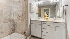 bathroom featuring walk in shower and dual vanity