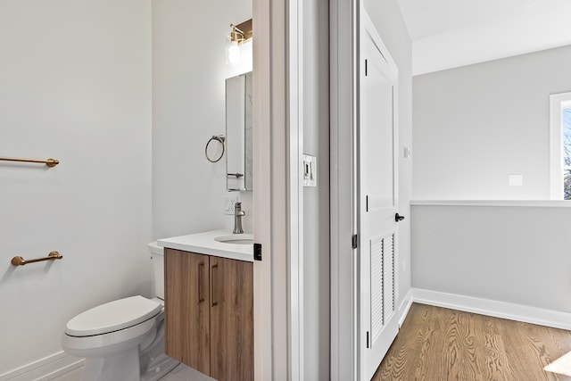 bathroom with hardwood / wood-style floors, vanity, and toilet