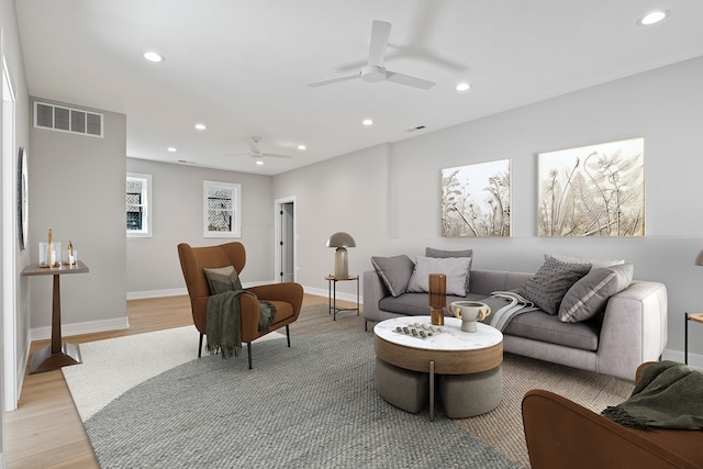 living room featuring ceiling fan and light hardwood / wood-style floors