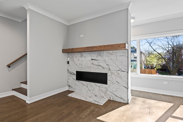 unfurnished living room featuring ornamental molding, dark wood-type flooring, and a high end fireplace