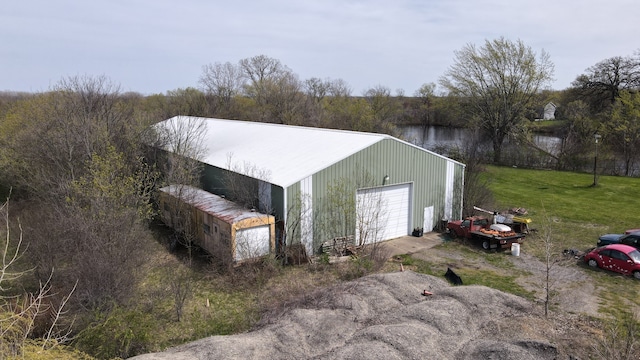 view of shed / structure with a lawn, a garage, and a water view