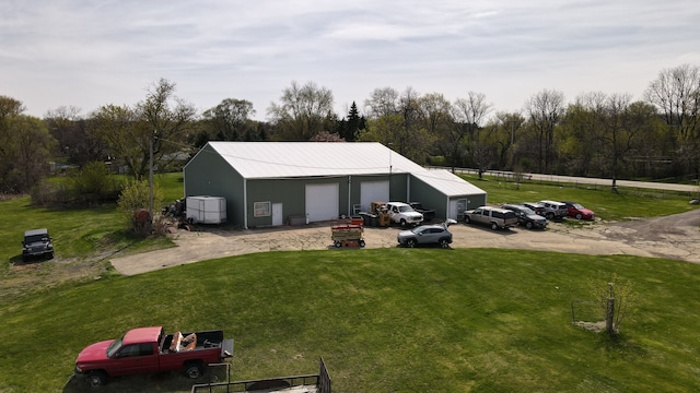 rear view of house featuring an outdoor structure and a lawn