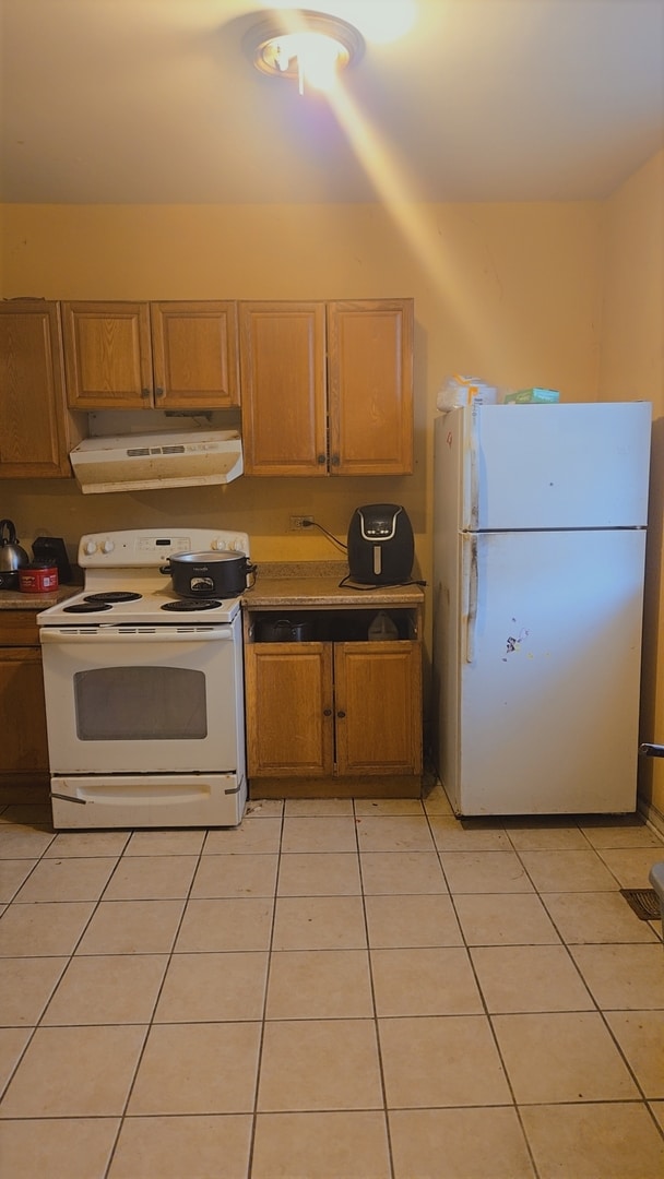 kitchen featuring white appliances and light tile floors