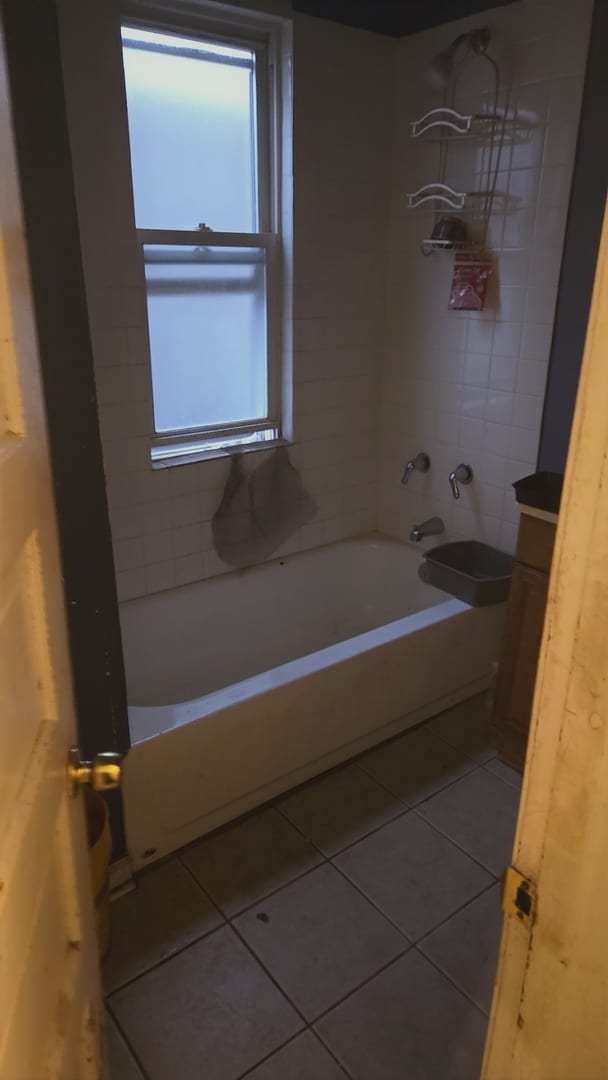 bathroom featuring tile floors and tiled shower / bath