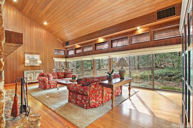 living room with wooden walls, a healthy amount of sunlight, high vaulted ceiling, and wooden ceiling