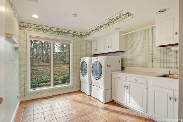 laundry room with cabinets, a wealth of natural light, sink, and washer and dryer