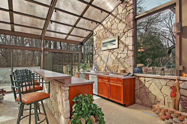 bar with light colored carpet, dishwasher, high vaulted ceiling, and sink